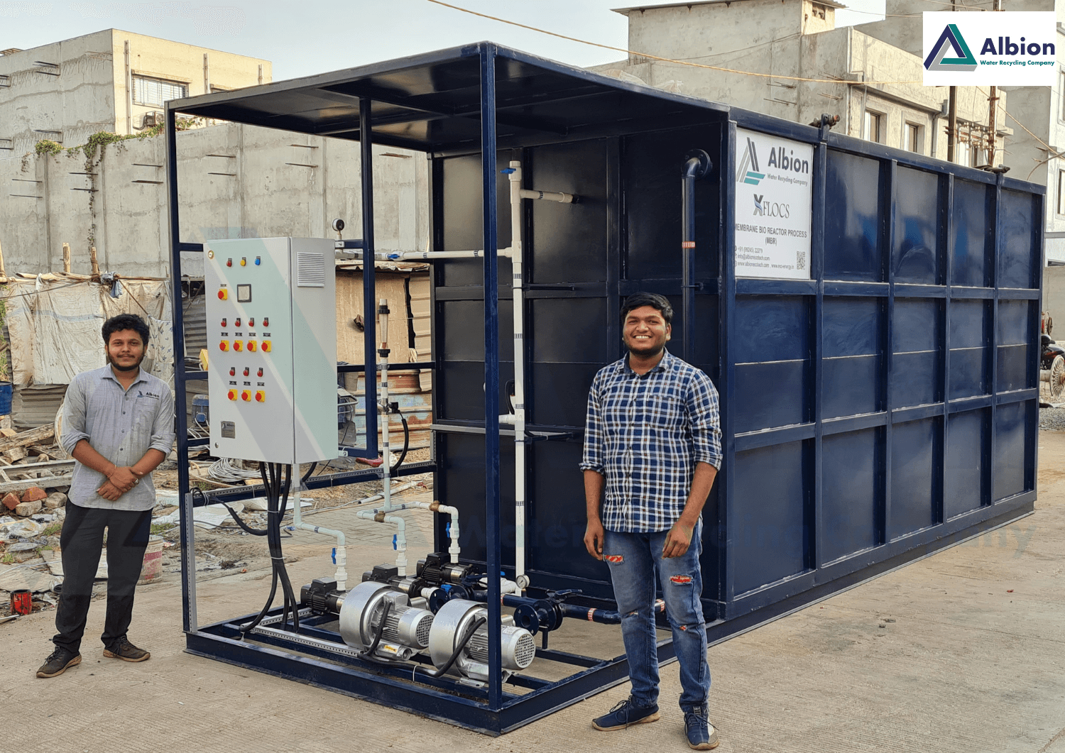 Technical team standing alongside a newly assembled 50 KLD sewage treatment plant module.